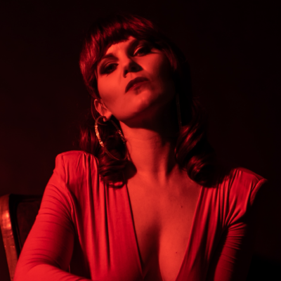 Monte in a red dress with a dark background. 
