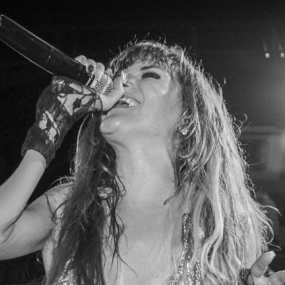 Monte singing on stage in black and white. 