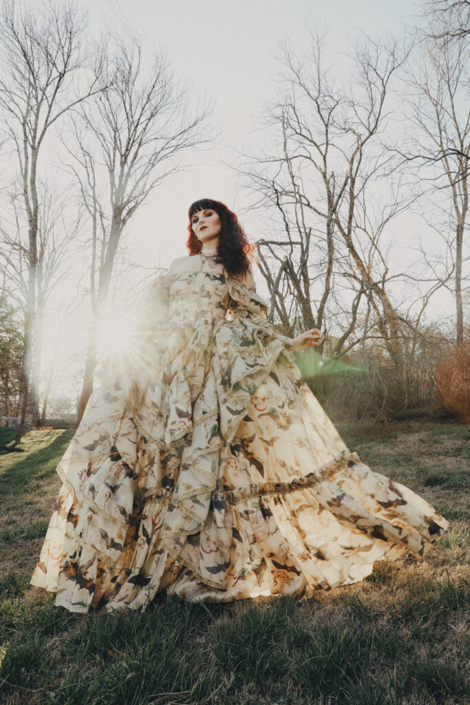 Monte Mader outside in a couture dress with sunshine in the background. 